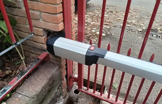 Attuatore lineare per cancello a battente fissato al pilastro in mattoni