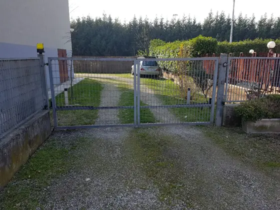 Cancello a due ante automatizzato con lampeggiante su strada privata