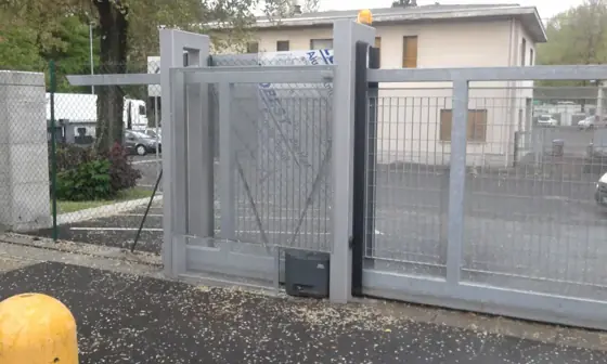 Cancello scorrevole automatico zincato all’ingresso di un’azienda, con lampeggiante