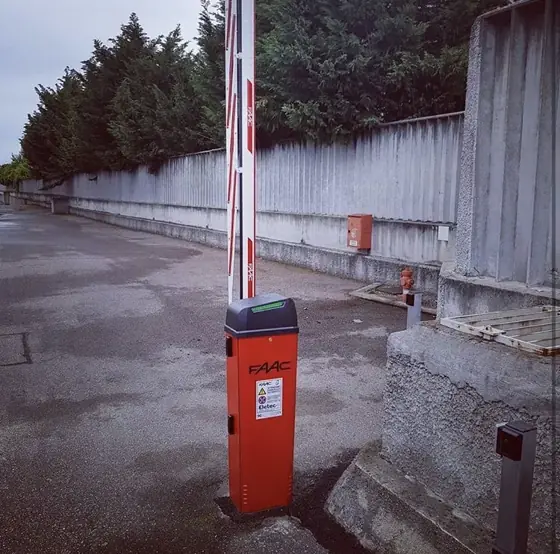 Barriera automatica FAAC con asta alzata all’ingresso di un’area privata